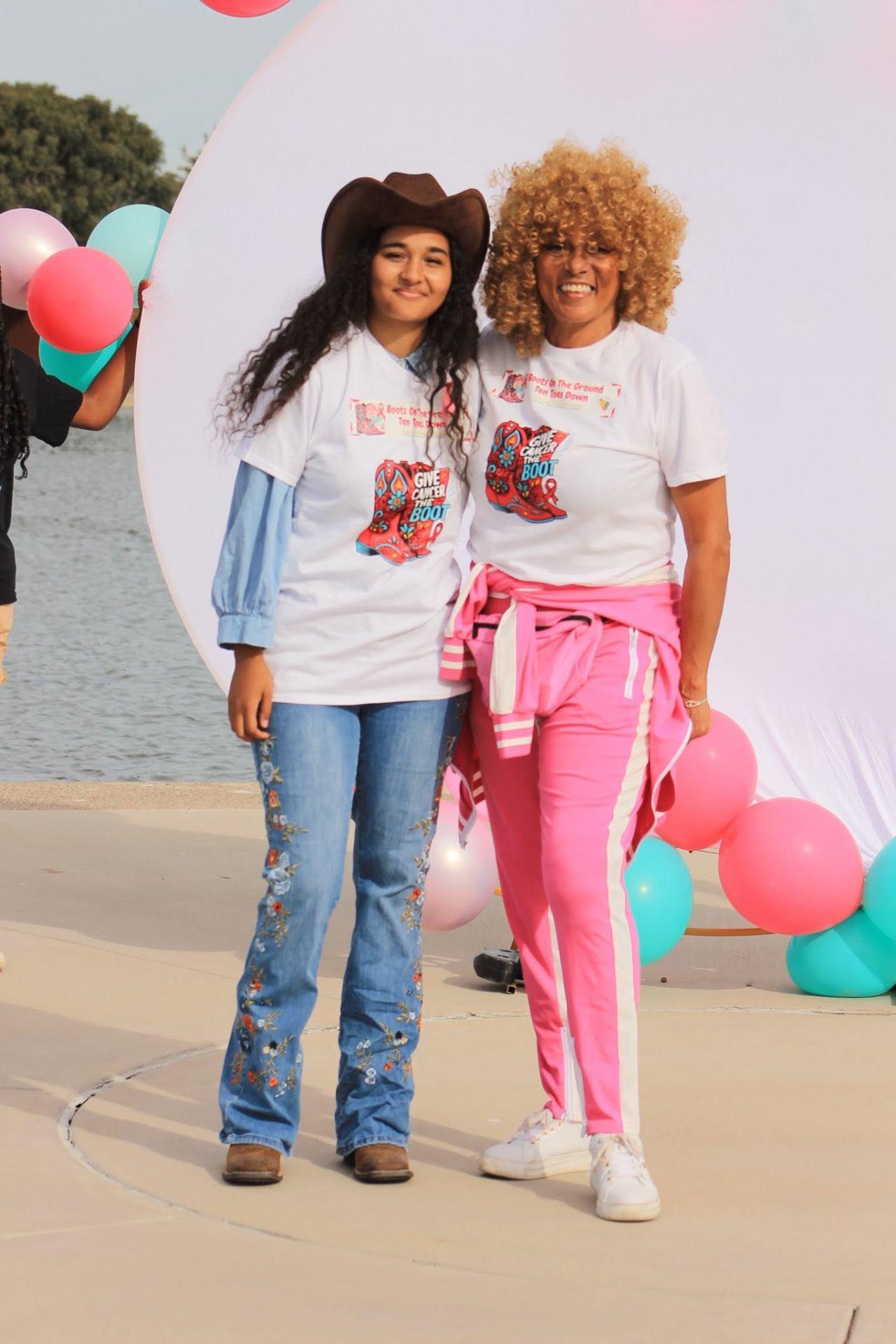Host and young cowgirl by the lake